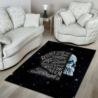 Black area rug featuring blue-toned skull graphic and decorative quote text