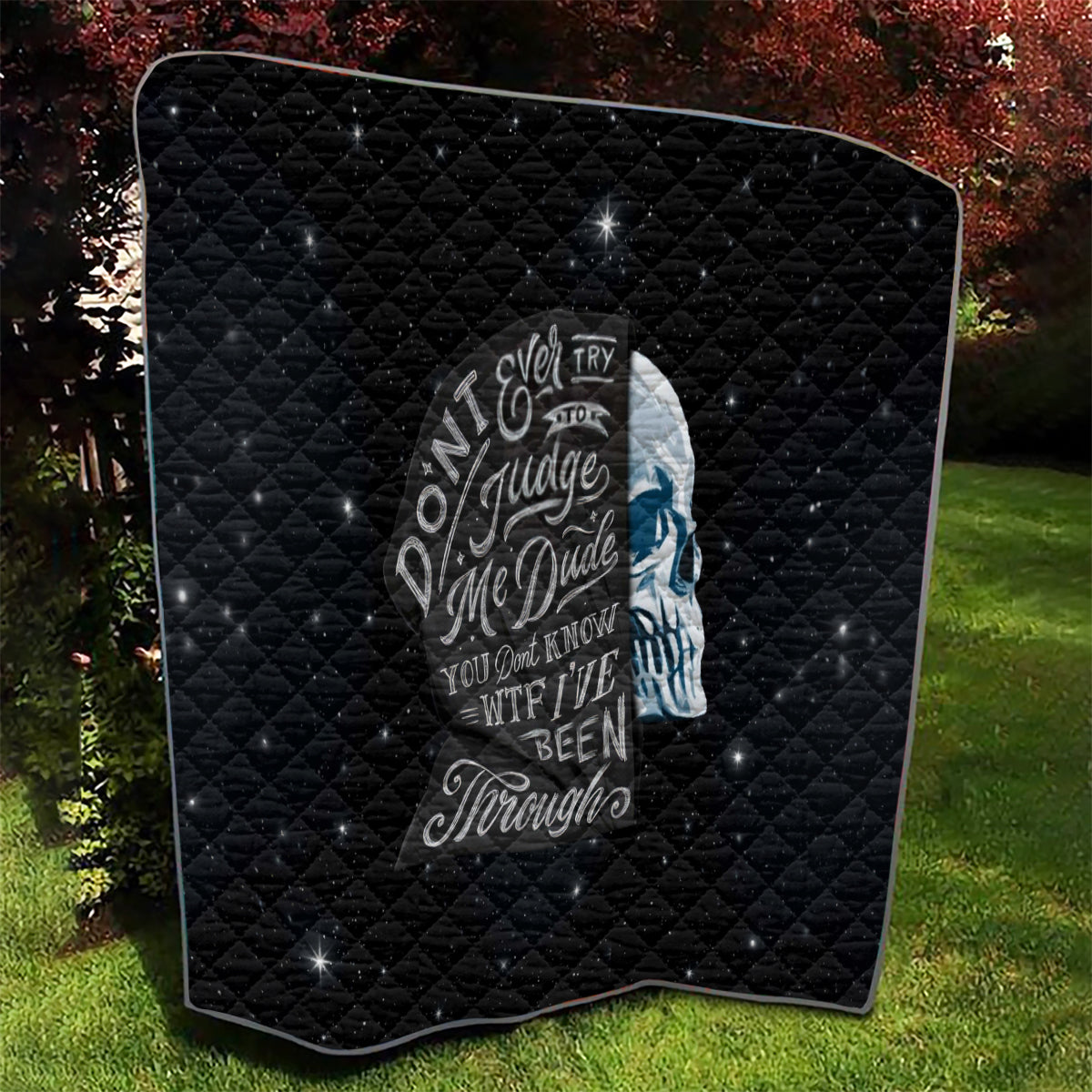 Black quilt with curved corner view; centered skull graphic and diamond quilted pattern