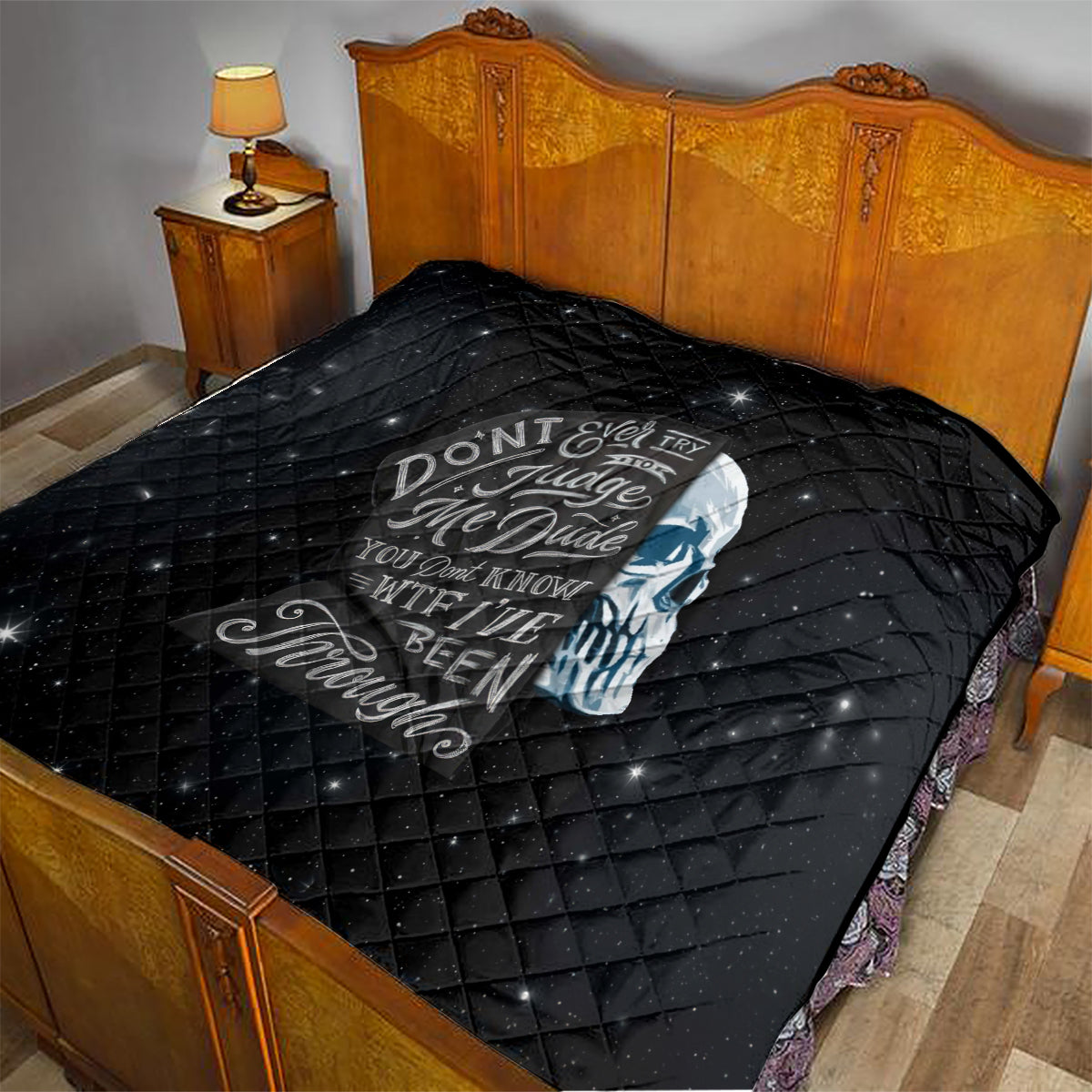 Black quilt on bed with diamond stitching and skull graphic across the center