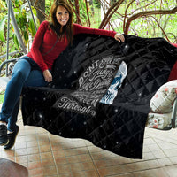 Black quilt laid on couch with skull graphic and diamond stitched stars; text centered