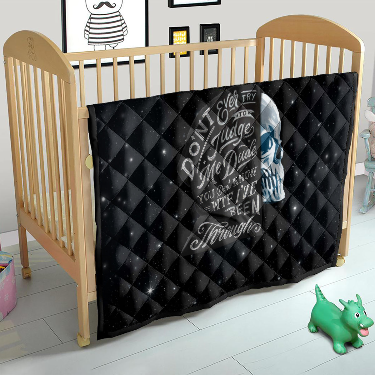Black quilt on toddler bed with skull graphic and diamond quilted texture