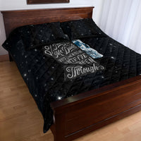 Black quilt bed set with blue skull print and quilted grid, with two matching pillows