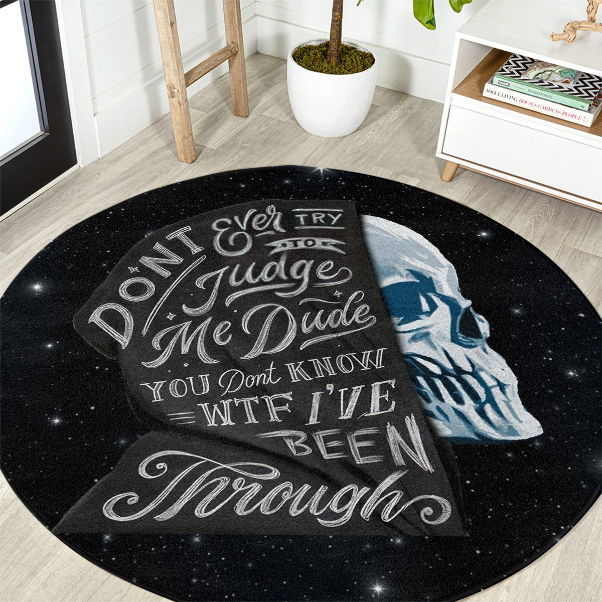 Round black area rug featuring blue skull face and white lettering on starry design