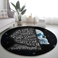 Round black area rug with blue skull portrait and white quote text, starry speckle