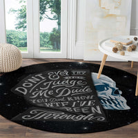 Round black area rug with large skull-and-text graphic, dark star pattern background