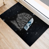 Black rubber doormat with blue-gray sad skull and “Don’t Ever Try To Judge Me” text