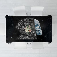 Black skull tablecloth laid flat, featuring skull, roses, and quote-style typography