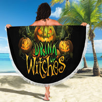 Round black beach blanket with large “Drink Up Witches” pumpkin graphic and fringed edge