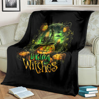 Black halloween witches throw blanket draped on a couch with green cauldron and jack-o-lanterns