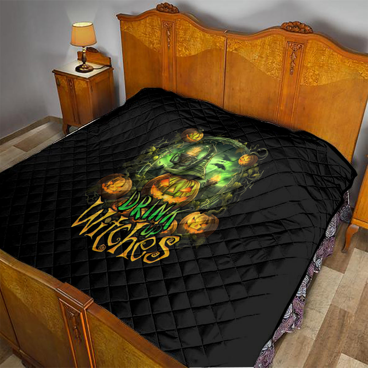Black quilted Halloween quilt on bed with green witch skull and orange pumpkin design
