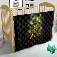 Black quilted Halloween quilt on wooden crib with green witch skull and orange pumpkin artwork