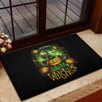 Black rubber doormat with green witch holding pumpkin and 'Drink Witches' lettering