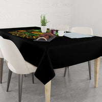 Black Halloween tablecloth draped over dining table with 'Drink up Witches' print.
