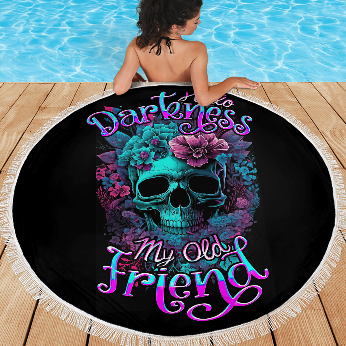 Black round beach blanket showing turquoise skull with purple-blue floral border and white fringe