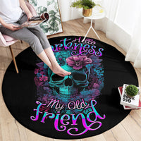 Black round area rug with turquoise skull, purple floral graphics, and stylized lettering