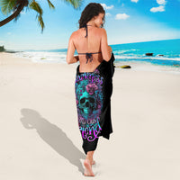Black sarong with purple skull and flowers print, tied at back with string.