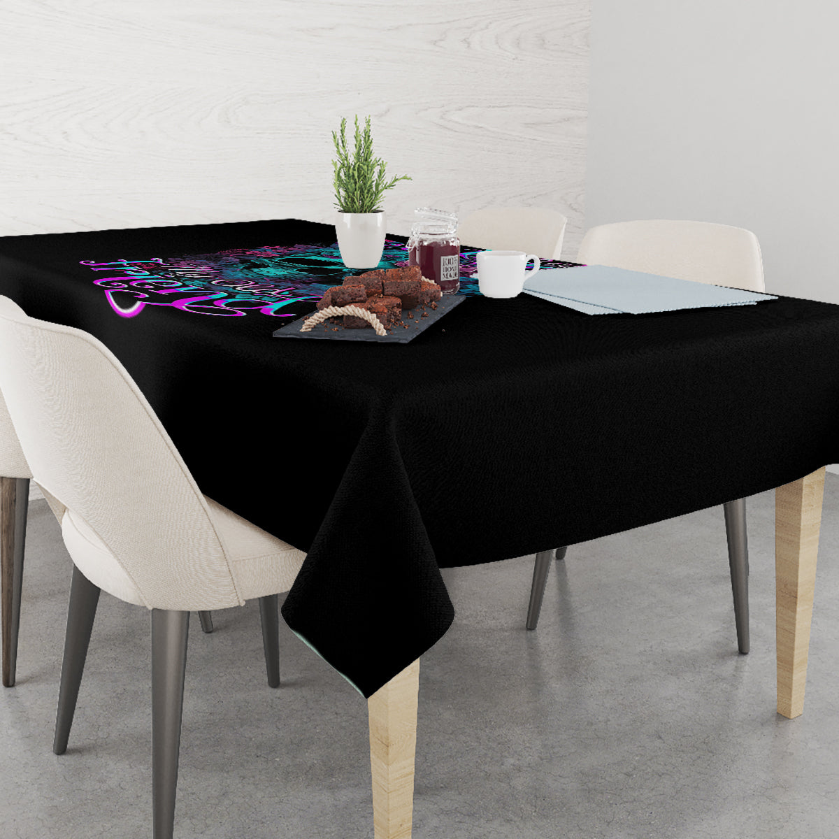 Black rectangular tablecloth with colorful skull and floral graphic near table center