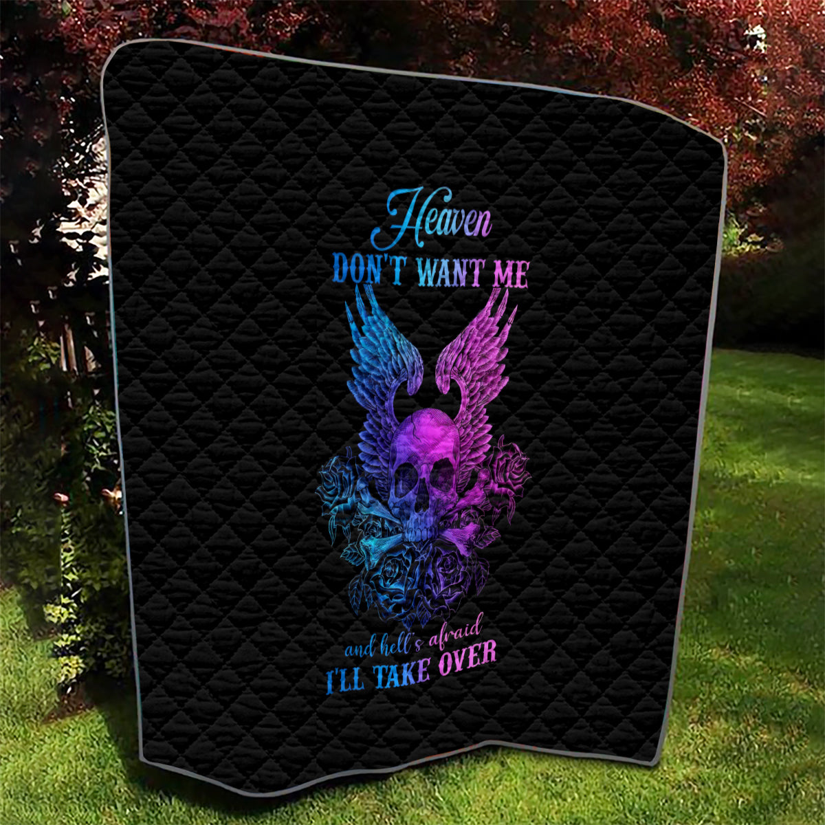 Black quilt blanket with diamond quilting and purple/blue winged skull graphic, framed corners