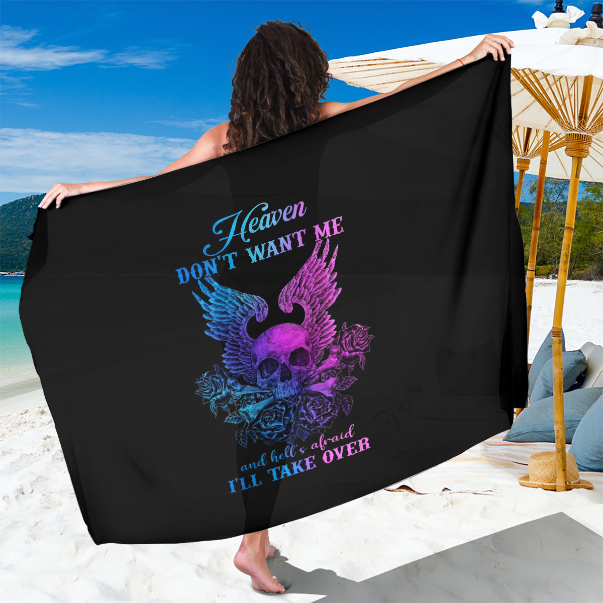 Black sarong with large purple skull-wing design and blue slogan, draped over one arm