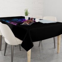Black tablecloth with blue and purple skull wing design draped over a dining table edge