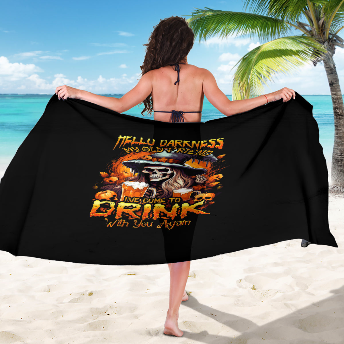 Black sarong with witch skull graphic and orange Halloween text, draped on model