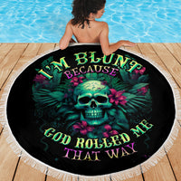 Round black beach blanket with teal skull and tropical lettering, fringed border on deck.