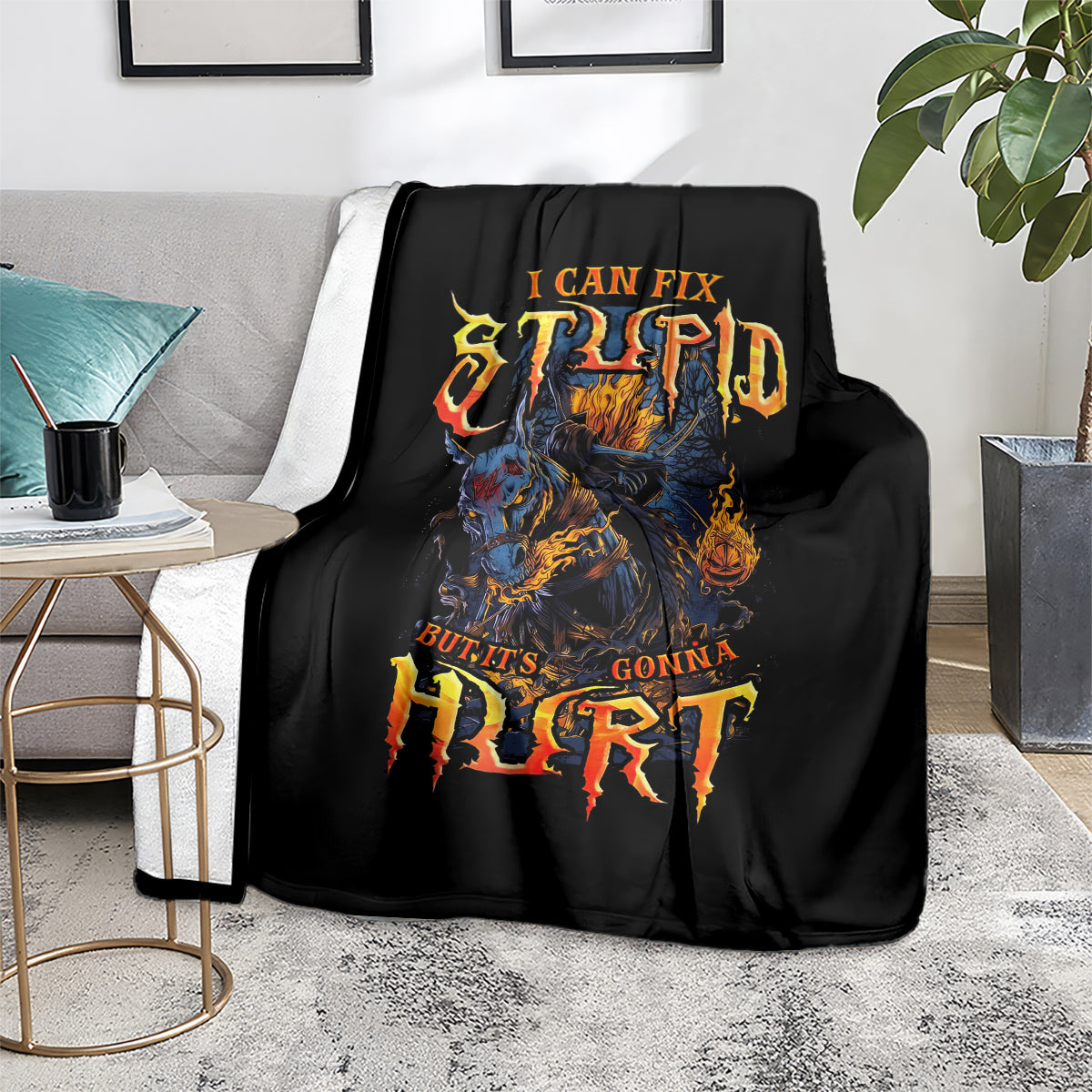 Black throw blanket showing fiery skull graphic with distressed text design