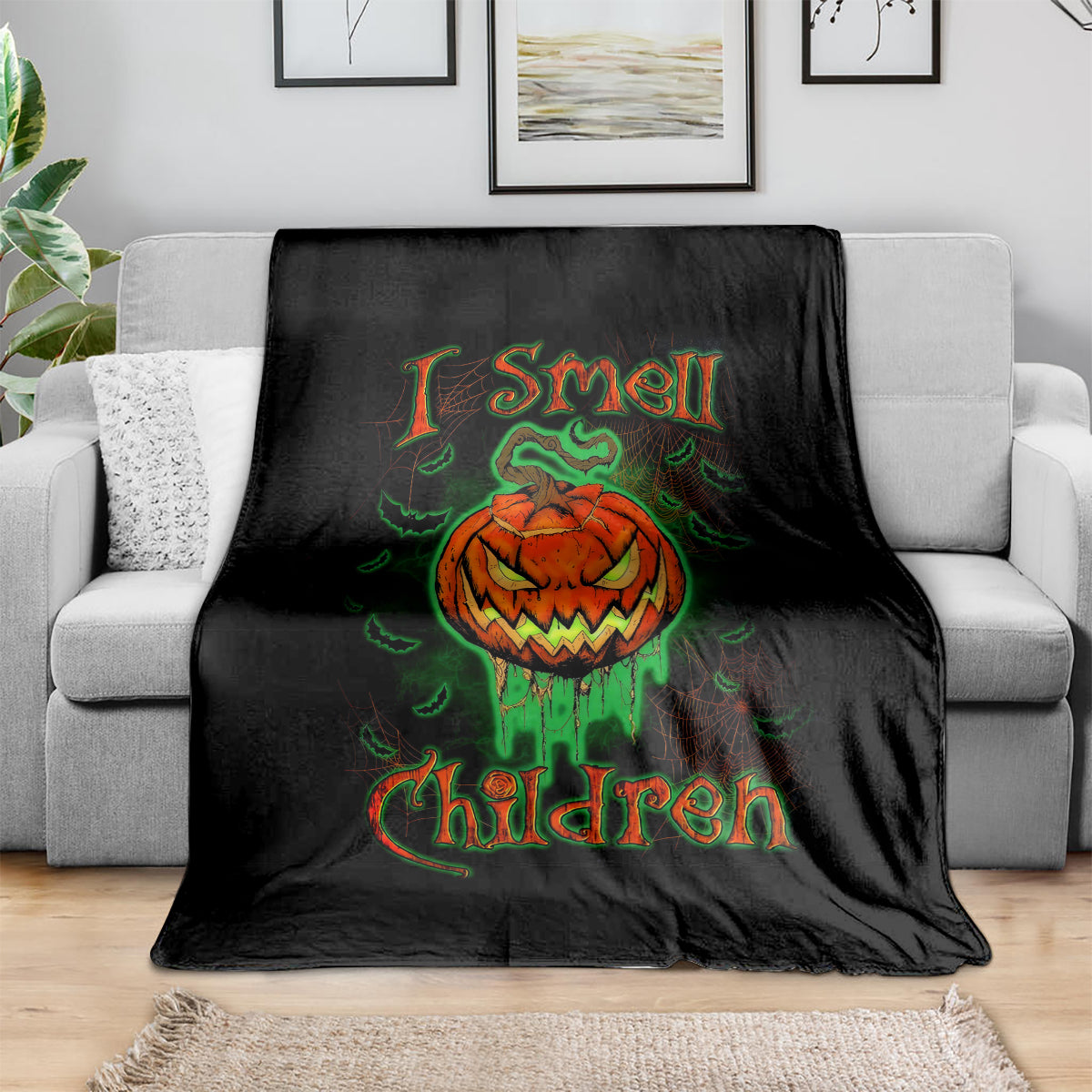 Black Halloween blanket with jack-o’-lantern skull graphic and green-orange text lettering