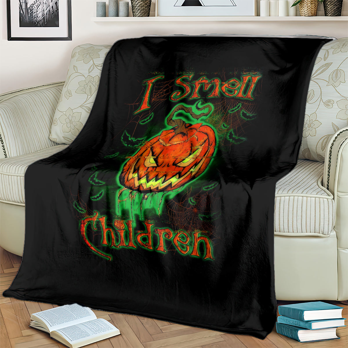 Black Halloween blanket laid on sofa with jack-o’-lantern skull and green-orange lettering