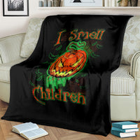 Black Halloween blanket laid on sofa with jack-o’-lantern skull and green-orange lettering