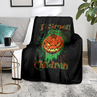 Black Halloween throw blanket on gray sofa with jack-o’-lantern skull graphic