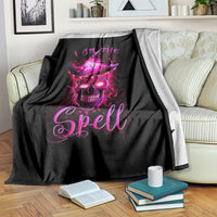 Black blanket with purple witch skull and 'I AM THE Spell' graphic, draped over arm