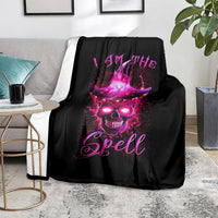 Black witch skull blanket with purple 'I AM THE Spell' design, laid on couch