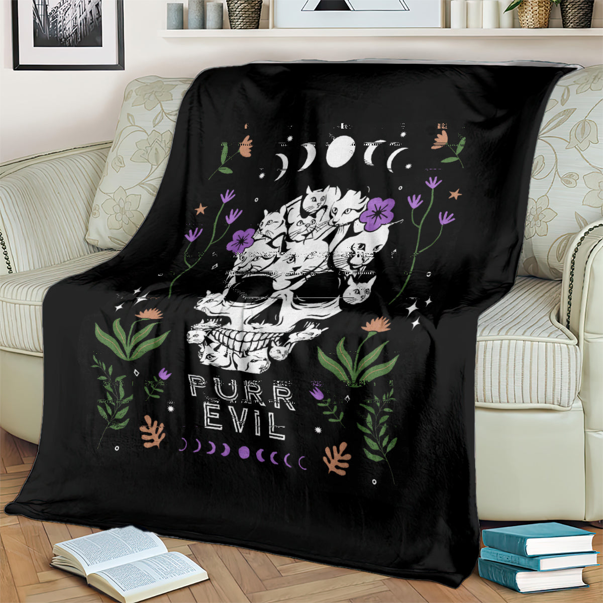 Black cat skull blanket draped on sofa with cats, flowers, moons, and 'PURR EVIL' design