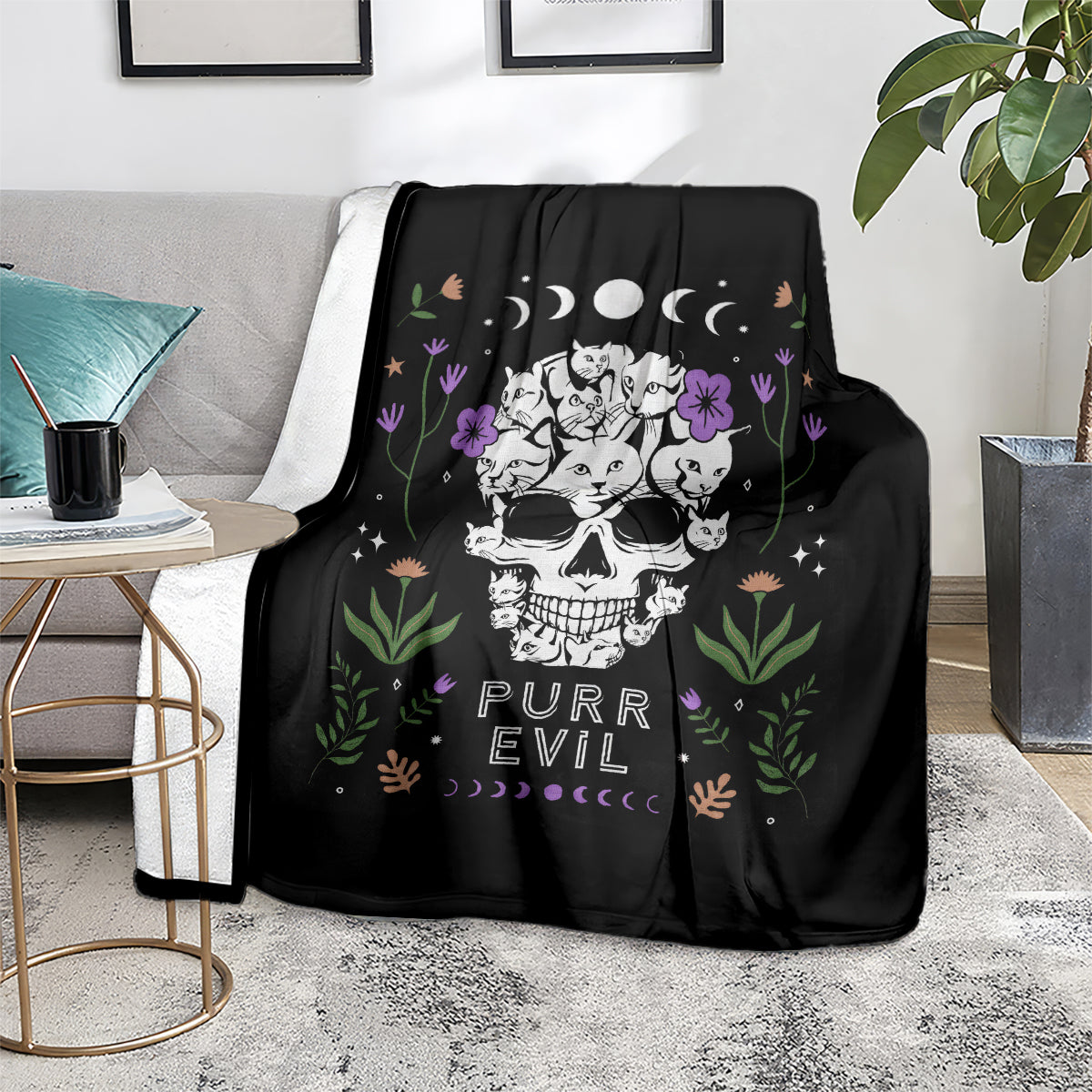 Black cat skull blanket on sofa with cats, flowers, moons, and 'PURR EVIL' design