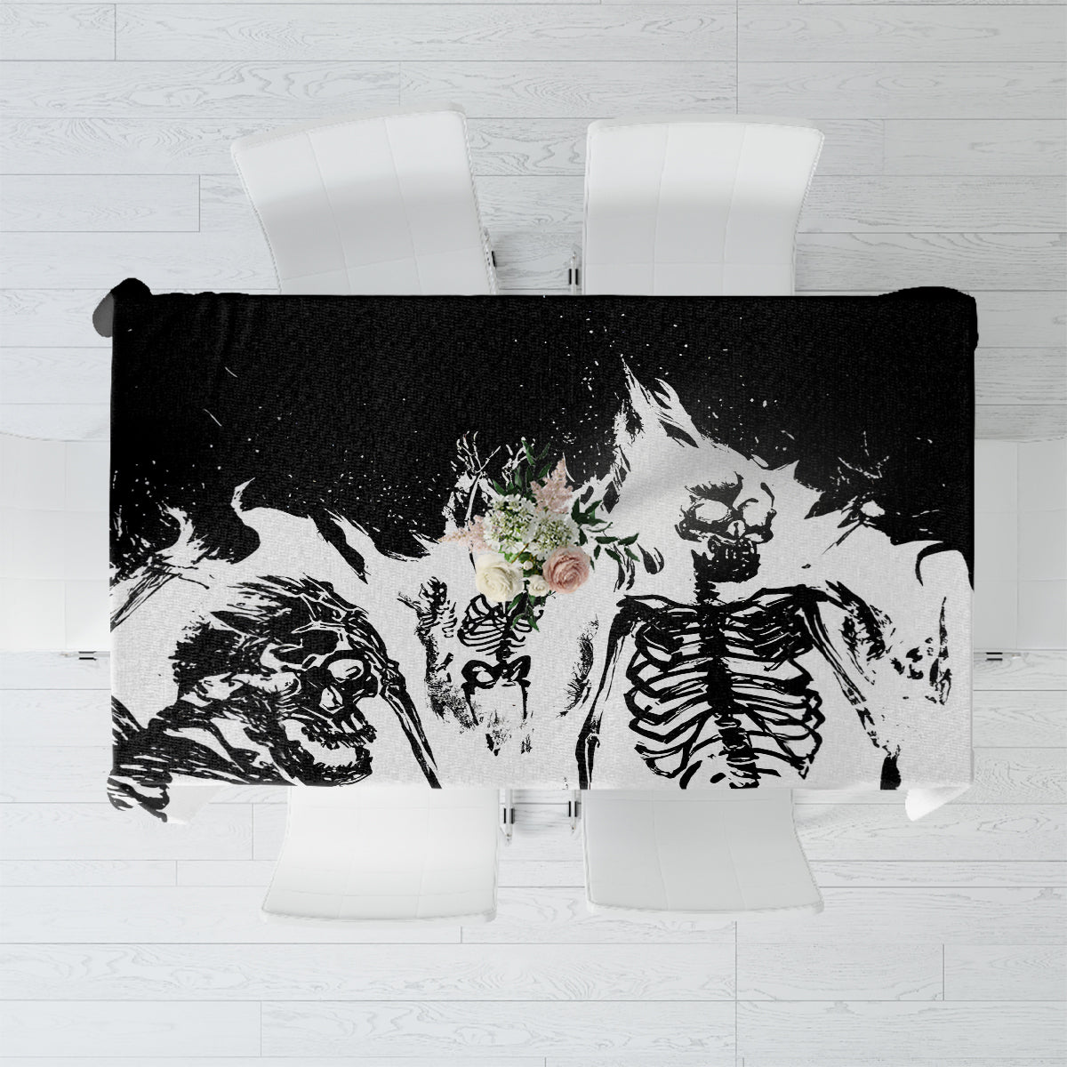 White tablecloth laid flat, black-and-gray skull and bone graphic with small floral accent.