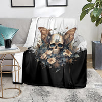 Gothic skull butterfly blanket on gray sofa, black body with cream floral accents