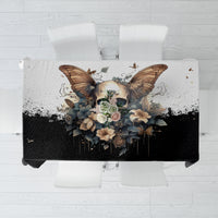 Black tablecloth with large butterfly skull artwork and floral arrangement, top view