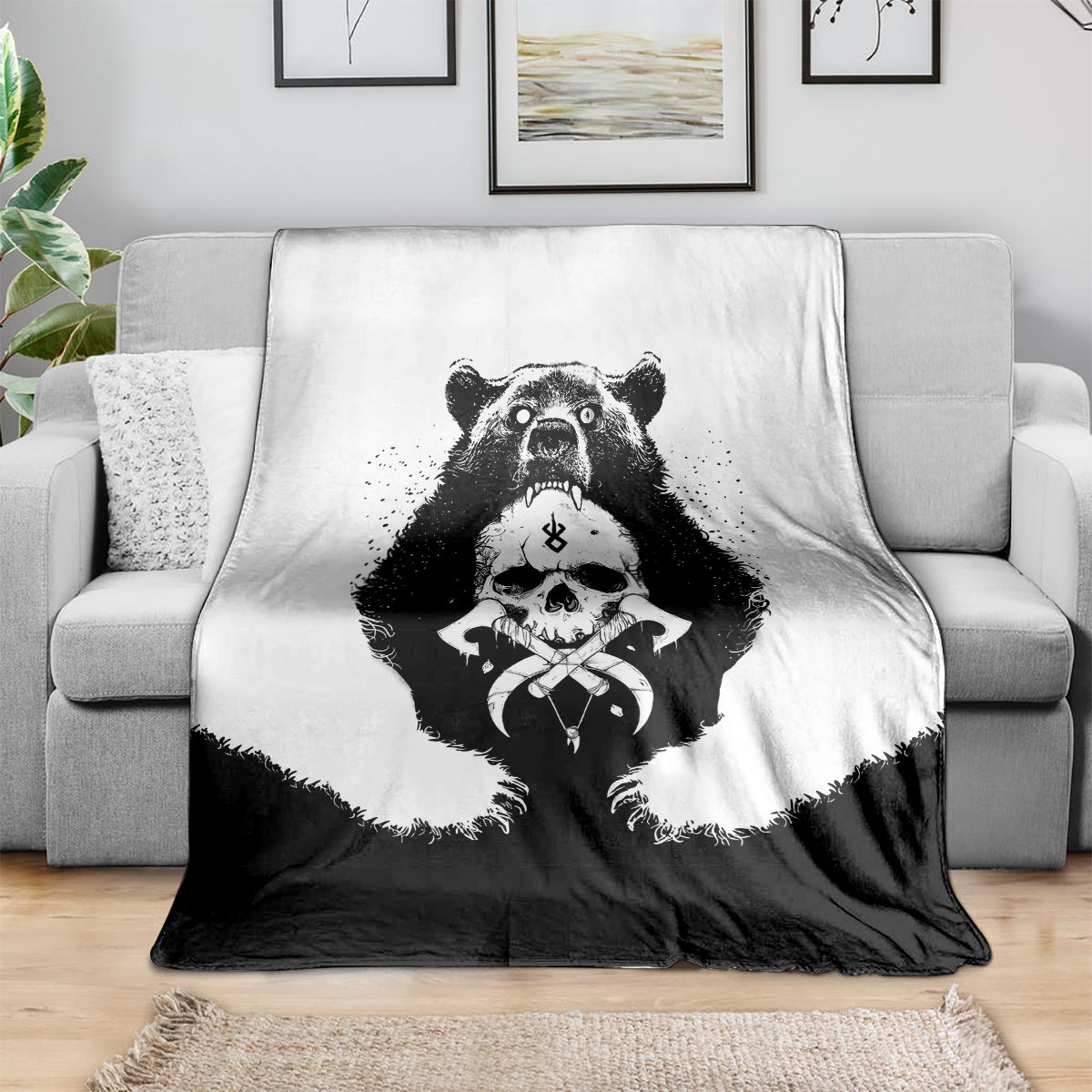 Black and white Viking bear skull throw blanket with crossbones graphic, draped on sofa