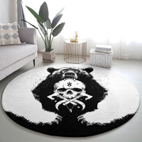 Round area rug with central bear skull emblem in black-and-white, dark outer trim