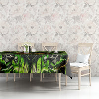 Black skull tablecloth with neon green graphic, draped over dining table edge
