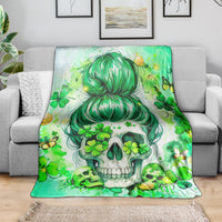 Green skull throw blanket with teal-haired girl and shamrocks, draped on gray sofa