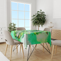 Green tablecloth with Irish skull and clover print on a dining table with 4 chairs.