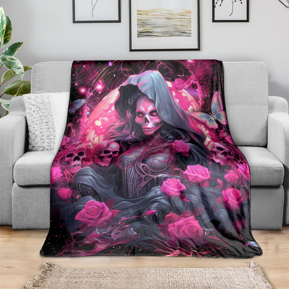 Black and magenta witch skull blanket with hooded woman and rose graphics, spread on sofa