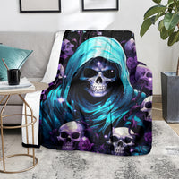 Skull-themed hooded blanket with blue hood graphic and purple roses, on gray couch