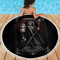 Black round beach blanket featuring grim reaper skeleton holding hourglass, white fringe trim
