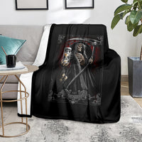 Black reaper skull graphic blanket with skeleton lantern and scythe, on living room chair