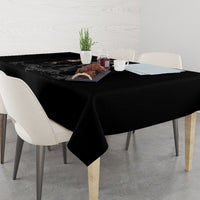 Black tablecloth with skull-and-reaper artwork on tabletop, corner overhang visible.