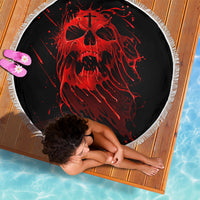 Black round beach blanket with red skull graphic and white fringed edge, top view
