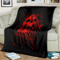 Black skull graphic blanket with red screaming skull design, spread on a couch